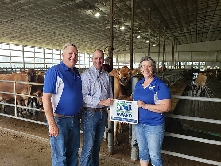 Secretary Naig presents the Good Farm Neighbor Award to the Maxwell family